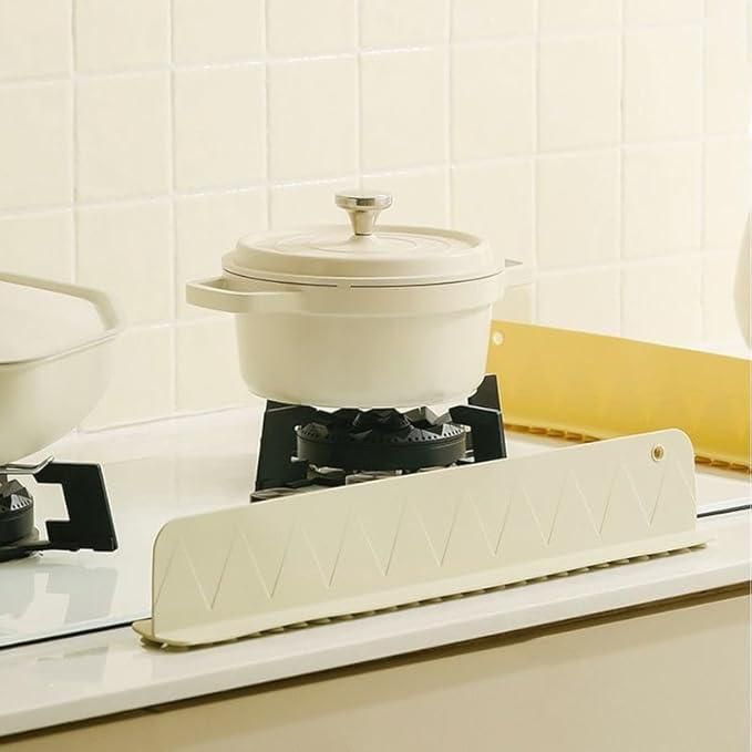 Cream-colored pot on gas stove with splash guard in modern kitchen at NayiDeals